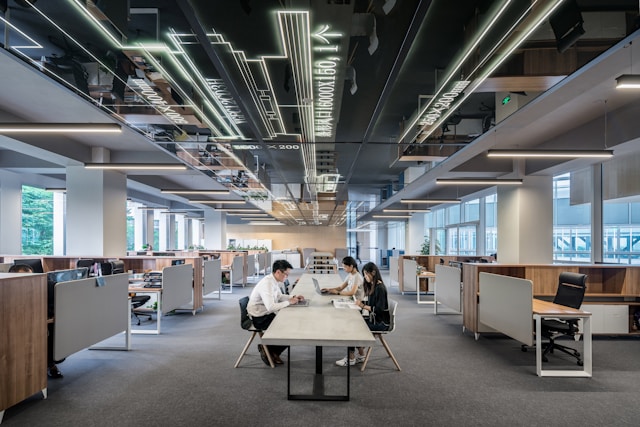 Employees collaborating at a conference table in the middle on an office